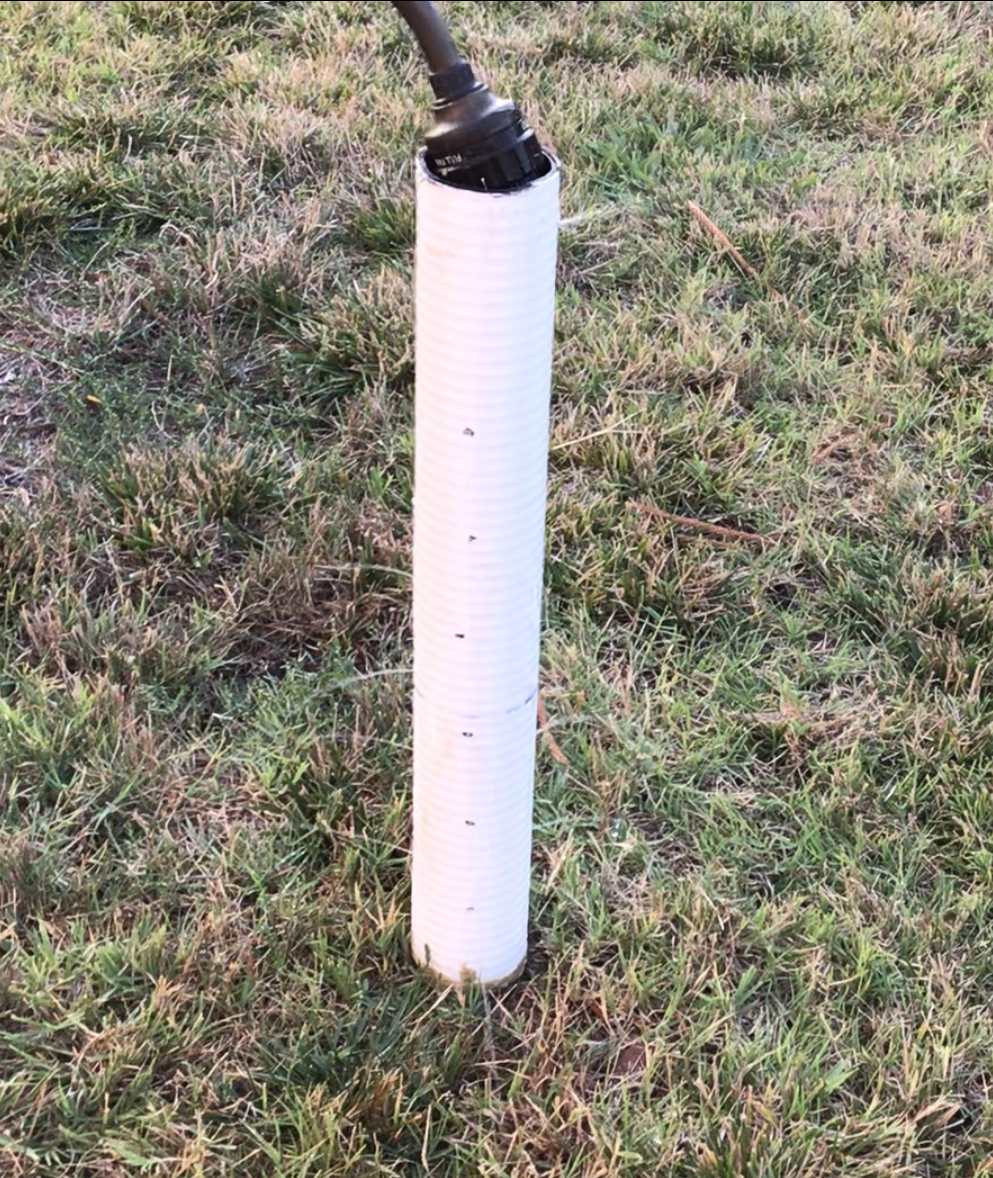 Drilling holes into the corrugated drain pipe.
