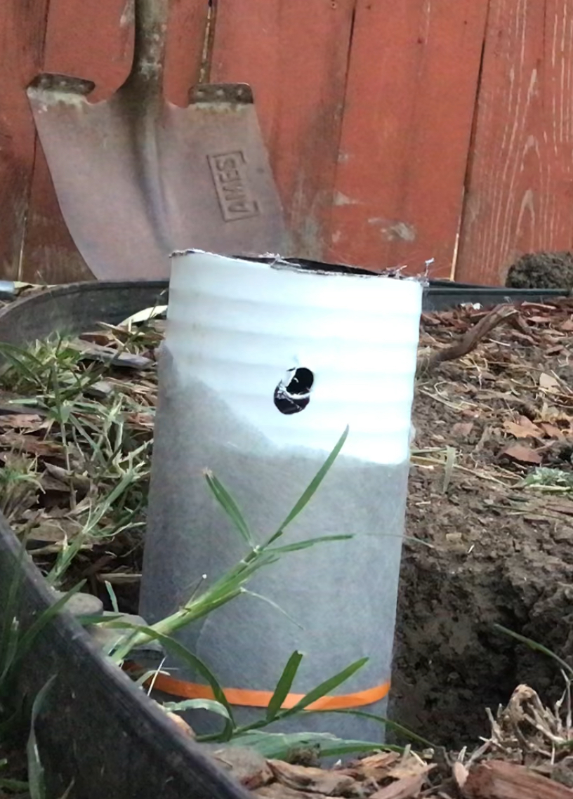 Pipe being prepared with cap and weed fabric.